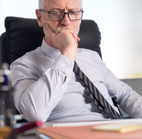 Businessman sitting at desk and looking contemplative