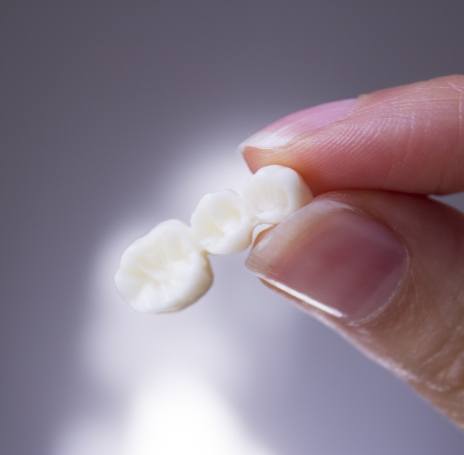 Dentist examining patient's smile after CEREC dental crown restoration