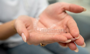 Closeup of patient holding clear aligner