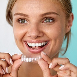 Smiling woman placing ClearCorrect alignment tray