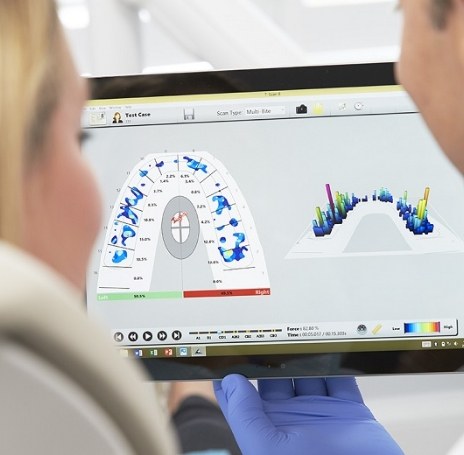 Dentist and patient looking at screen of cavity detection system