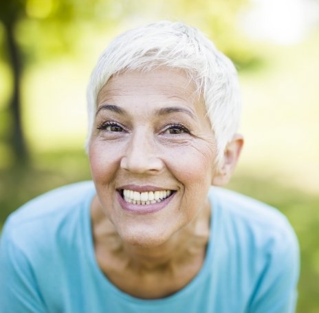 Senior woman grinning outdoors