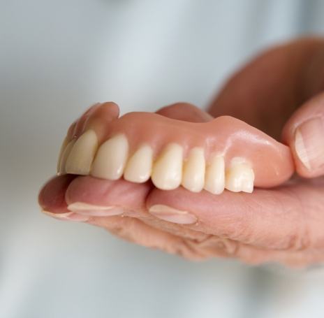 Dentist holding a full upper denture
