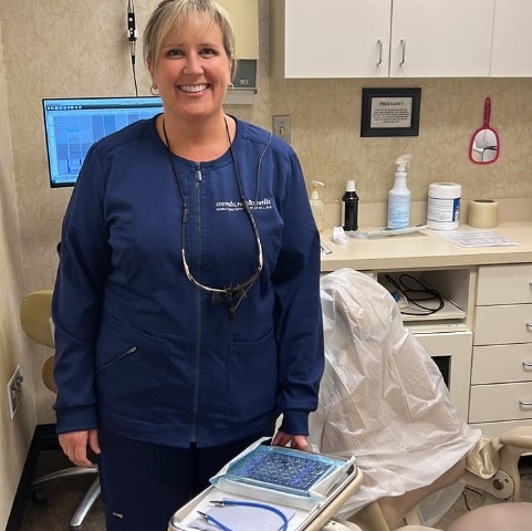 Dental team member standing next to empty treatment chair