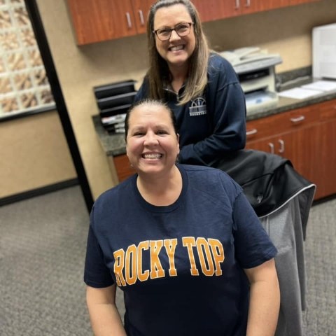 Two smiling dental team members in treatment room