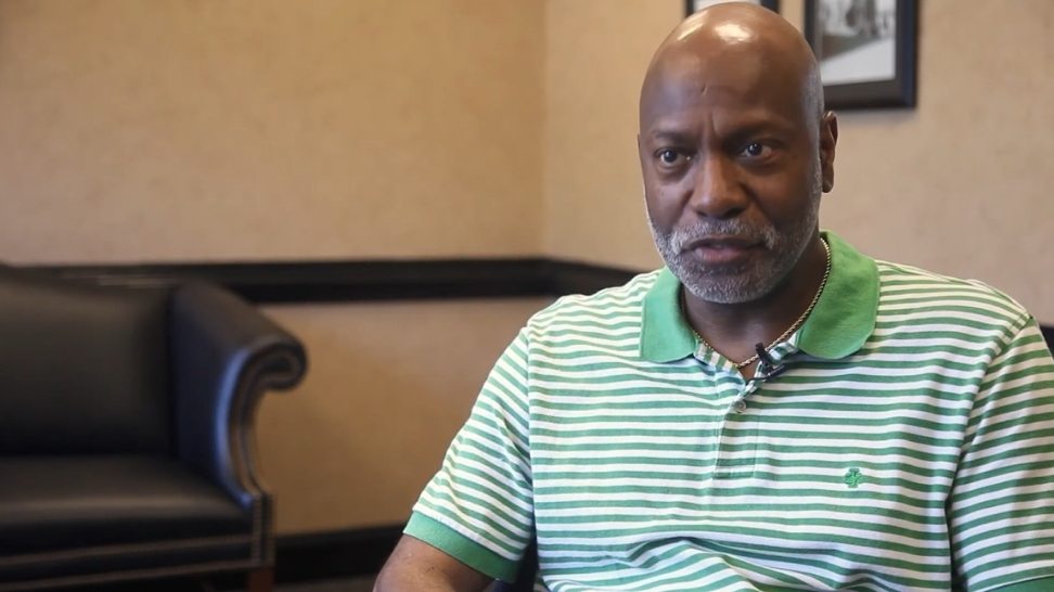 Man in green and white striped polo shirt sitting in Rock Hill dental office