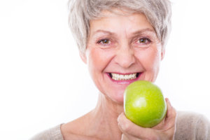 older woman holding an apple