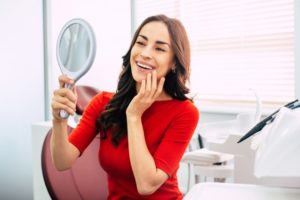 a patient smiling and examining their dental implants