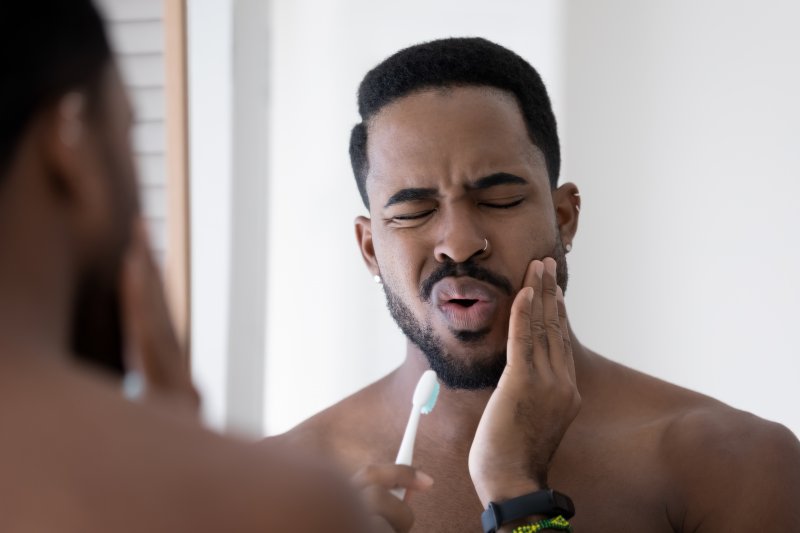 Man touching his jaw due to a root canal failure