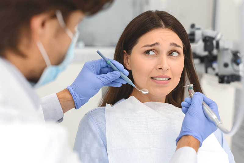 A scared woman looking at her dentist