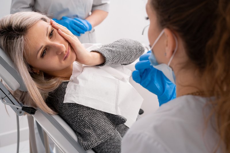 A woman suffering from a dental emergency