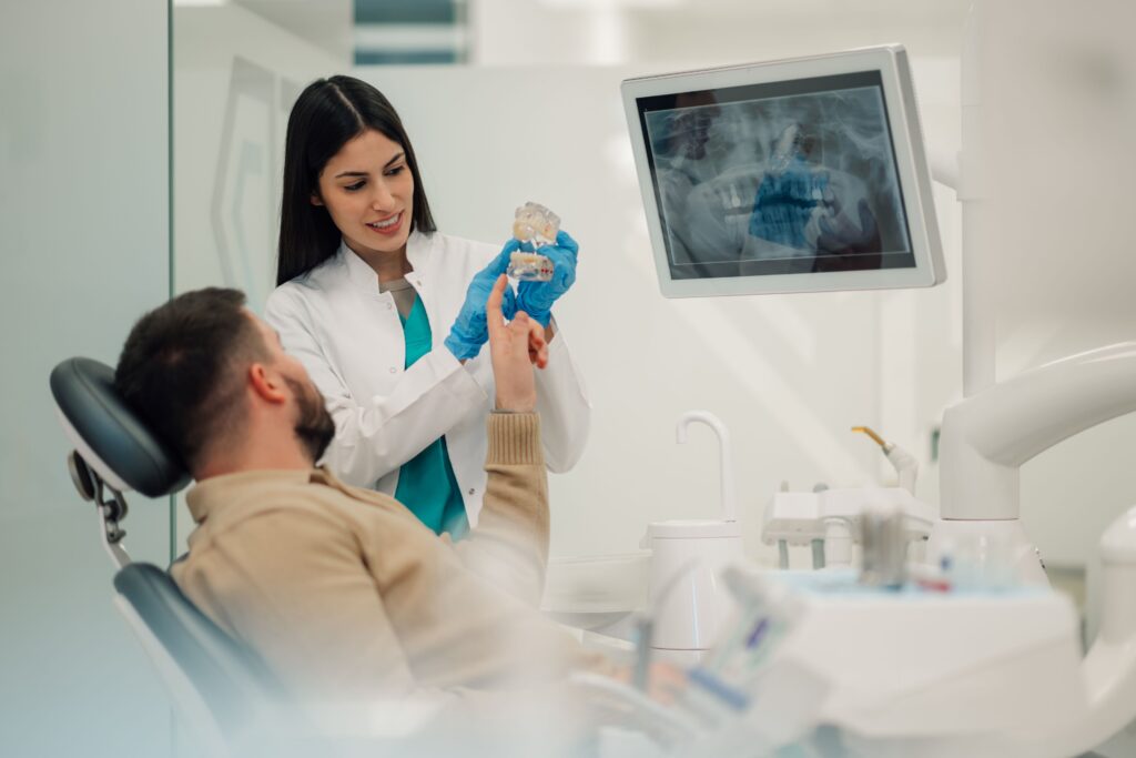 Dentist showing patient sample implant and results of his X-rays
