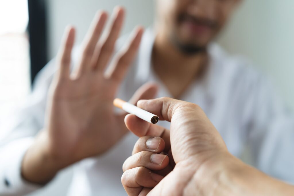 Man refusing offer of a cigarette held out to him