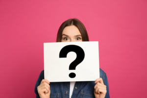 Woman holding up a card with a giant question mark on it