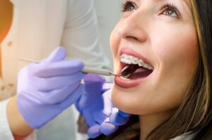 Woman with braces being examined by dentist.